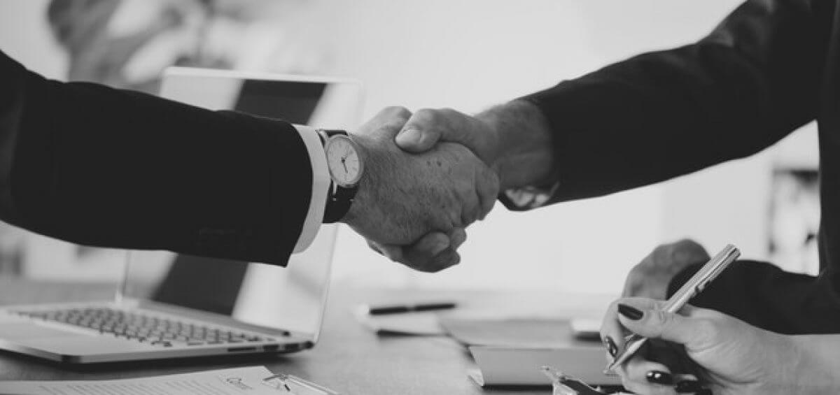Two businesses shaking hands over a deal