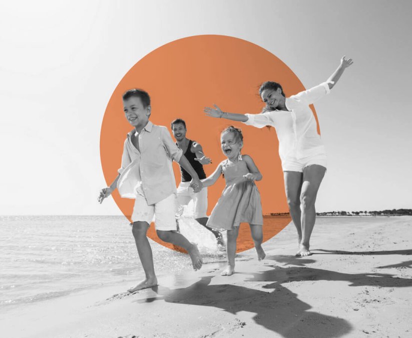 Young family running on beach with Interstaff orange circle in background