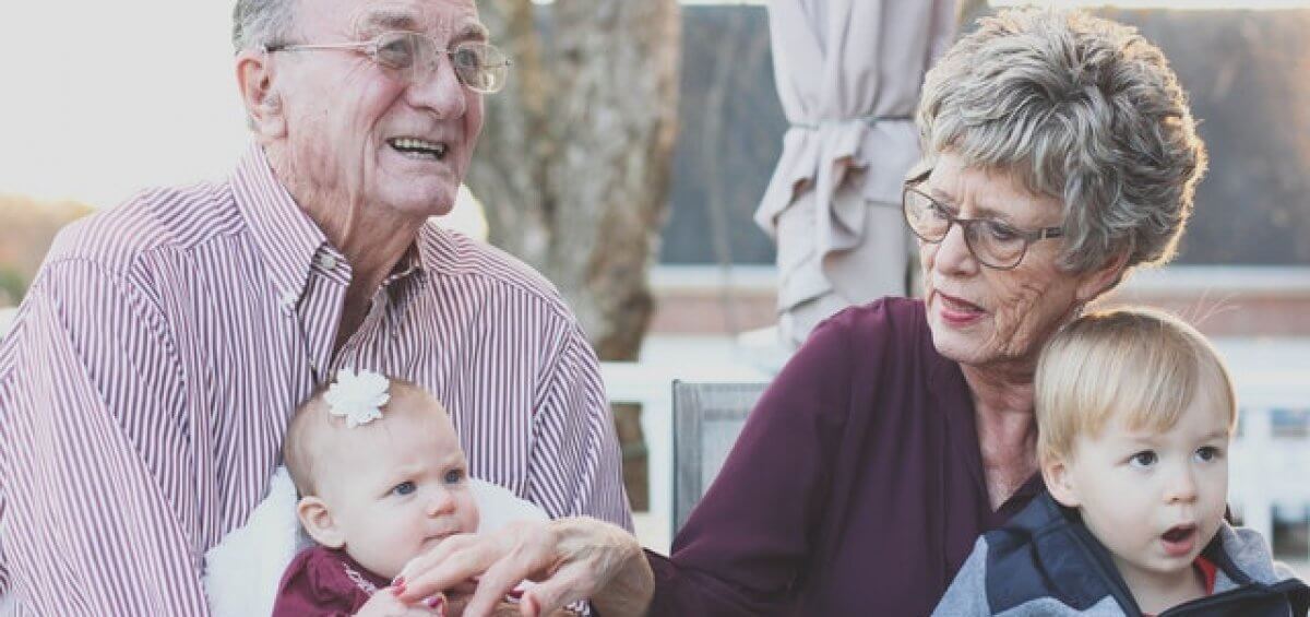 Grandparents holding their young grandchildren as a result of the new visa that brings parents to Australia