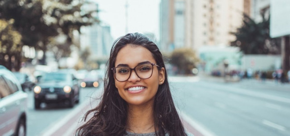 Young woman wearing glasses smiling about the 5 trends in Australian permanent residence migrants need to know