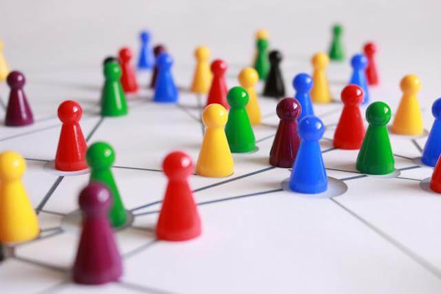 Coloured board game pieces arranged on a surface, connected by thin lines